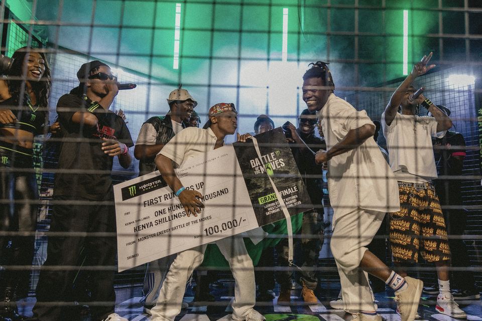 The first runners-up celebrating on the floor under the green stage lights.